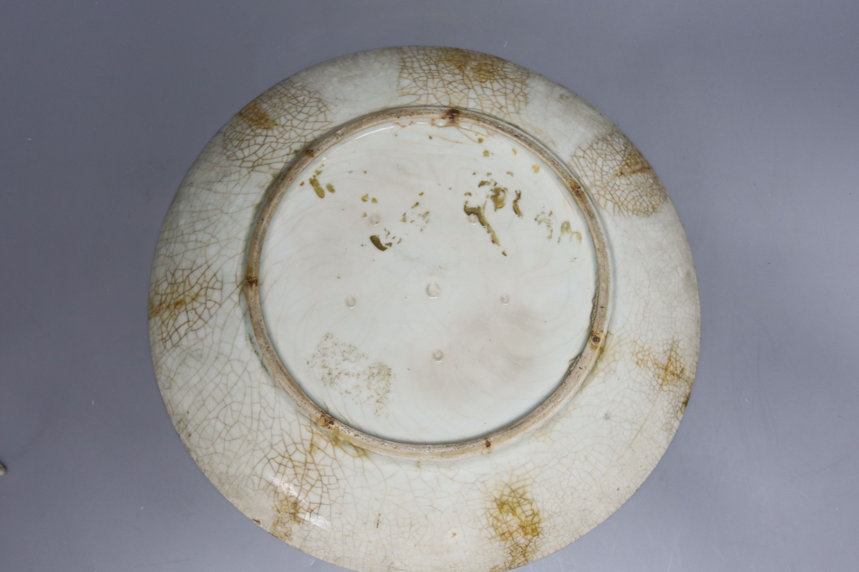 A Japanese crackle glazed dish, another similar and a Chinese celadon glazed dish, largest diameter 29.5cm